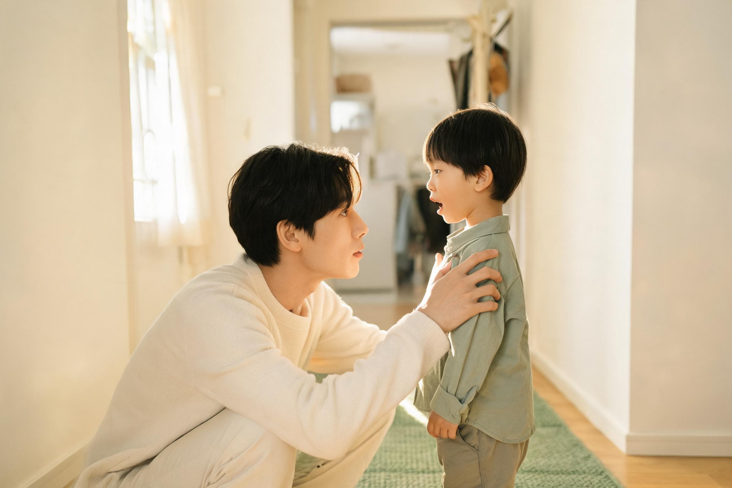 A parent kneeling to their toddler鈥檚 eye level, listening
